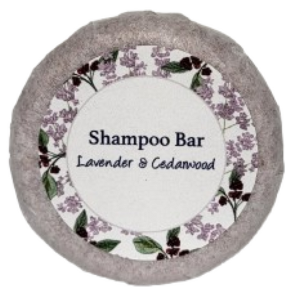 A round bar of orange, patchouli and lavender shampoo on a blank background