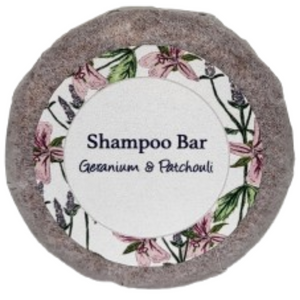 A round bar of geranium and patchouli shampoo on a blank background