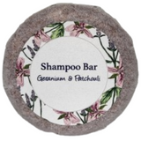 A round bar of geranium and patchouli shampoo on a blank background