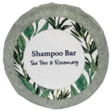 A round bar of tea tree and rosemary shampoo on a blank background